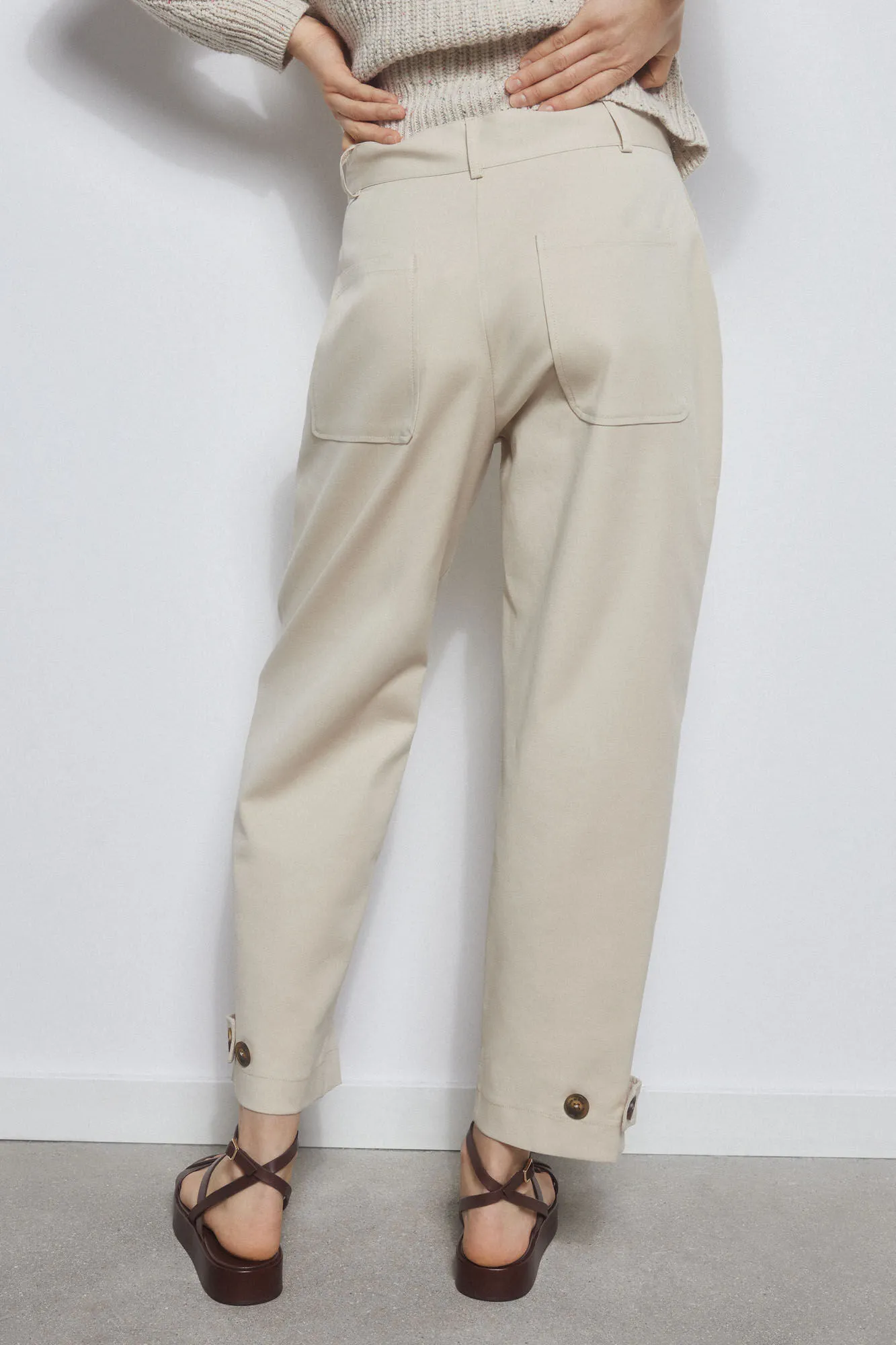 Trousers with adjustable darts on the hem